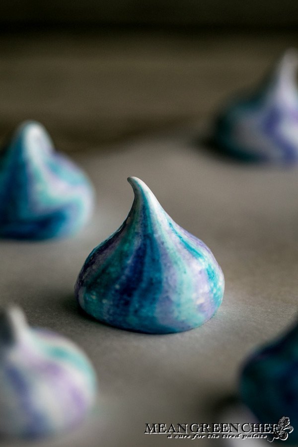 Strawberry Meringue Cookies piped onto a baking sheet lined with parchment paper.