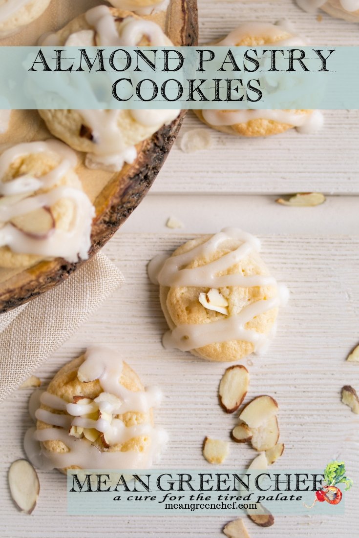 Overhead photo of Almond Pastry Cookies on white wooden background with roasted almonds sprinkled around.