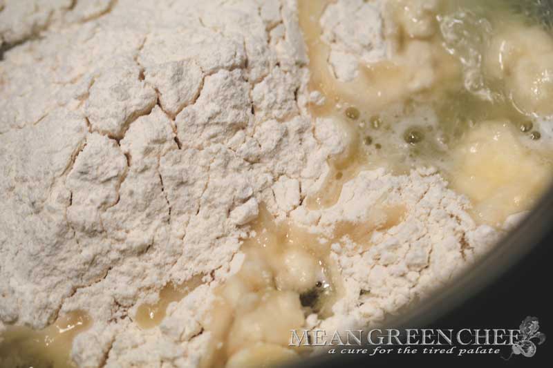 Pate a Choux Pastry ingredient flour, butter, salt and water being combined in saucepan on the stove top.