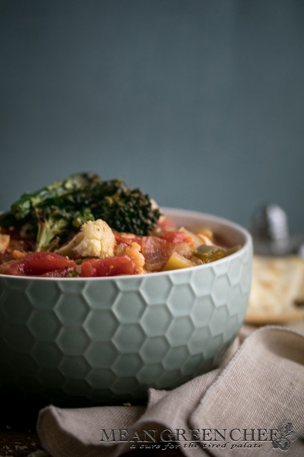 Side photo of a honeycomb pattern blue bowl filled with Hearty Vegetable Soup, Mean Green Chef.