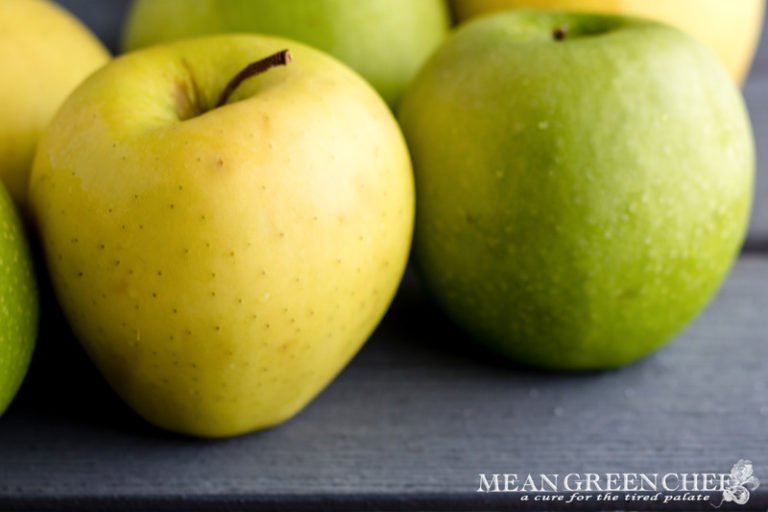Granny Smith and Golden Delicious Apples on a gray wooden background. Mean Green Chef