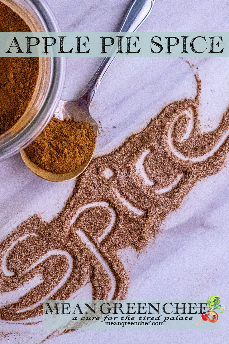 Apple Pie Spice used to spell out Spice in a fancy swirled font, with a small glass bowl and silver spoon each containing some spice. Mean Green Chef