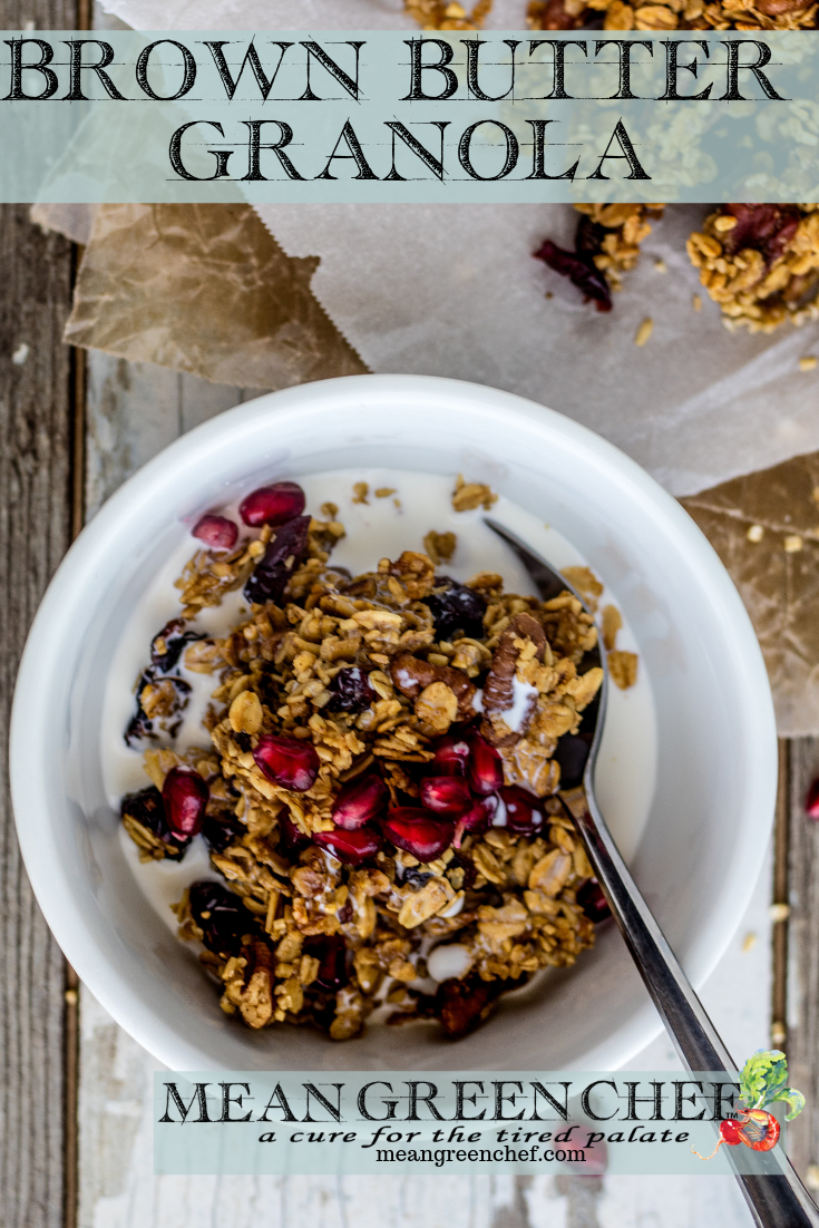 Overhead photo of a bowl of Brown Butter Granola in a white bowl garnished with pomegranate seeds on a wooden background. Mean Green Chef