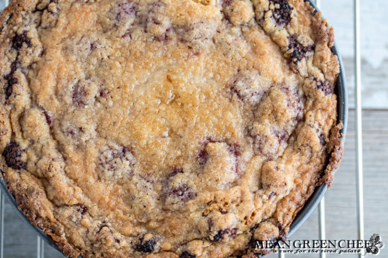 Baked Raspberry Coffee Cake cooling on a wire rack on a wooden background.