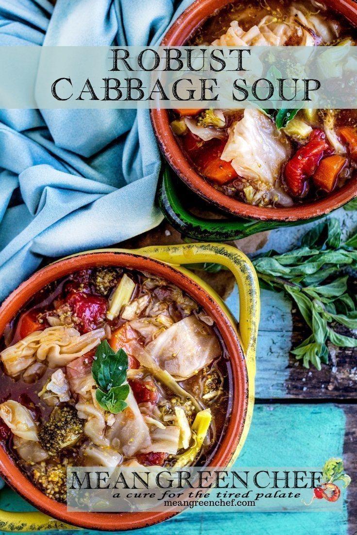 Overhead photo of Robust Cabbage Soup in two crocks one yellow one green with oregano on an old blue wooden background. Mean Green Chef