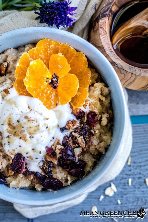 Overhead shot of a bowl of Spiced Mandarin Pecan Oatmeal garnished with whipped cream and Sumo Citrus.