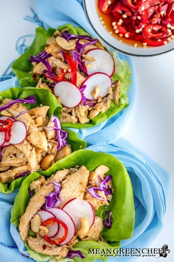 Thai Chicken Lettuce Wraps on a white background with Prik nam pla.