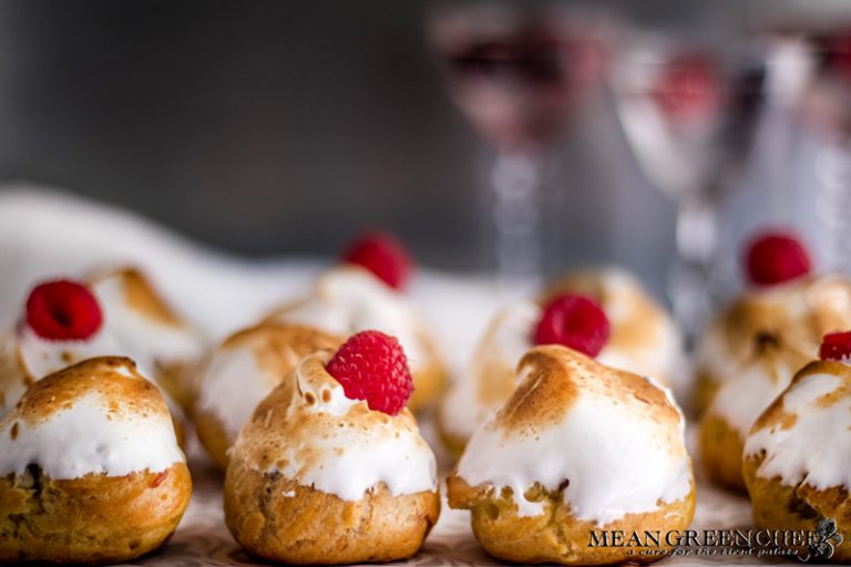 Rich Chocolate Creme Patissiere Pastry Cream in cream puffs with Swiss Meringue and red raspberries on top.