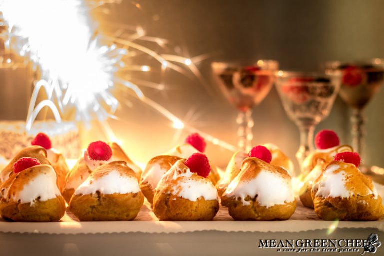 Rich Chocolate Creme Patissiere Pastry Cream in cream puffs with Swiss Meringue and red raspberries on top.