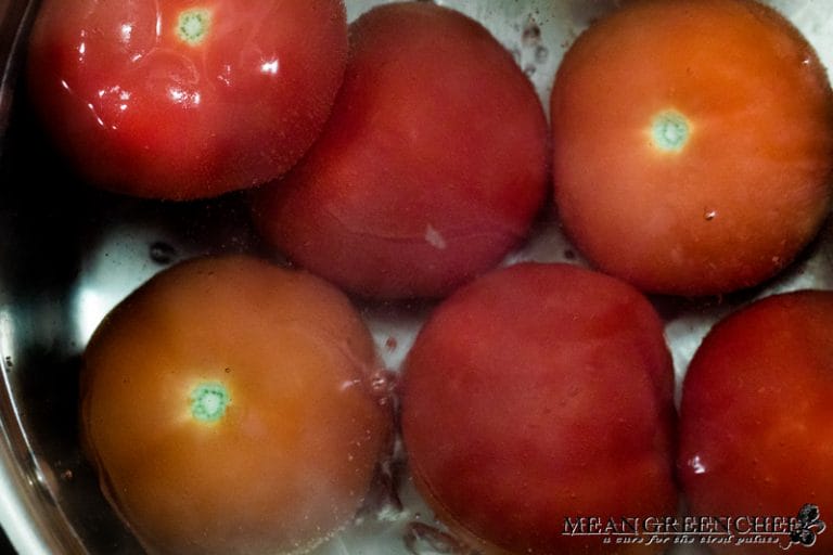 Pot with ripe tomatoes boiling in hot water to be blanched.
