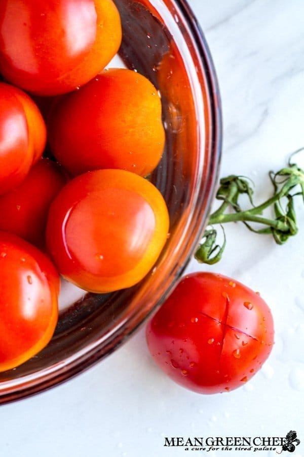 Bowl of red ripe tomatoes getting ready to be blanched.