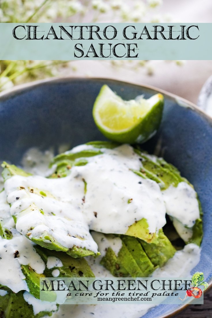 Cilantro Garlic Sauce over freshly sliced avocado in a blue bowl.