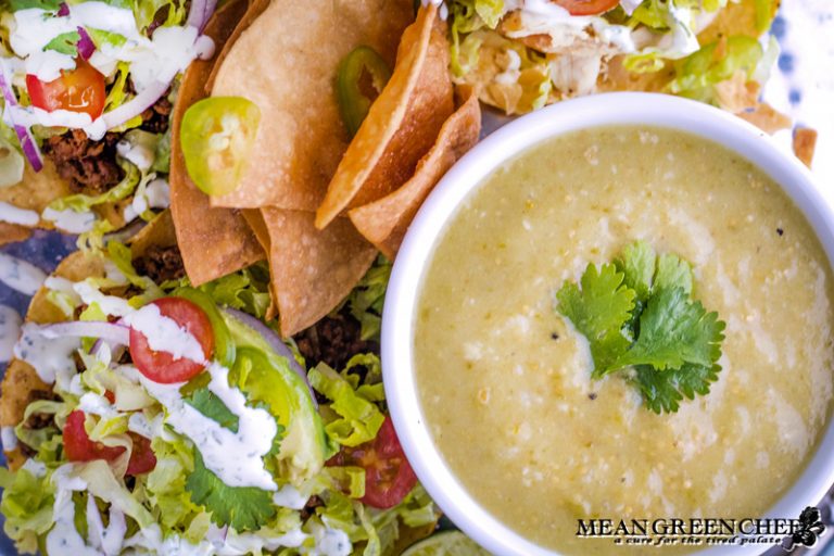 Bowl of Roasted Salsa Verde pictured with tostadas and fresh tortilla chips.