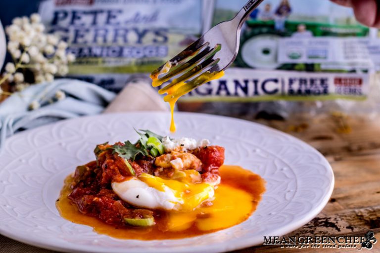 A plate of Shakshuka with a fork with dripping egg yolk.